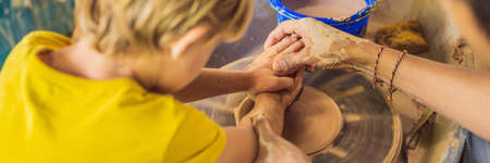 Mother and son doing ceramic pot in pottery workshop.