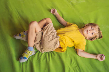 Boy resting after climbing a rock wall indoorの写真素材