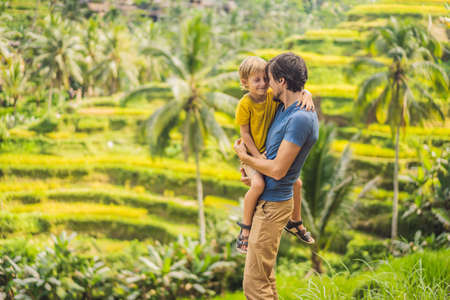 Dad and son travelers on Beautiful Rice Terraces against the background of famous volcanoes in Bali, Indonesia Traveling with children conceptの写真素材