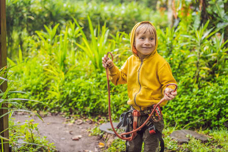 Little boy in a rope park. Active physical recreation of the child in the fresh air in the park. Training for childrenの写真素材