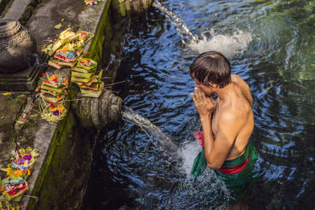 Man in holy spring water temple in bali. The temple compound consists of a petirtaan or bathing structure, famous for its holy spring waterの写真素材