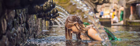 Woman in holy spring water temple in bali. The temple compound consists of a petirtaan or bathing...
