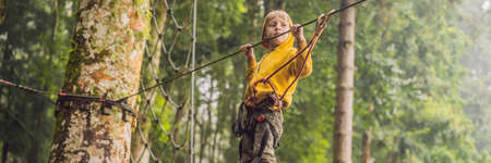 Little boy in a rope park. Active physical recreation of the child in the fresh air in the park. Training for children BANNER, LONG FORMATの写真素材