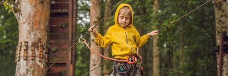 Little boy in a rope park. Active physical recreation of the child in the fresh air in the park. Training for children BANNER, LONG FORMATの写真素材