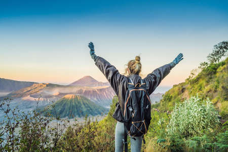 Young woman meets the sunrise at the Bromo Tengger Semeru National Park on the Java Island,...