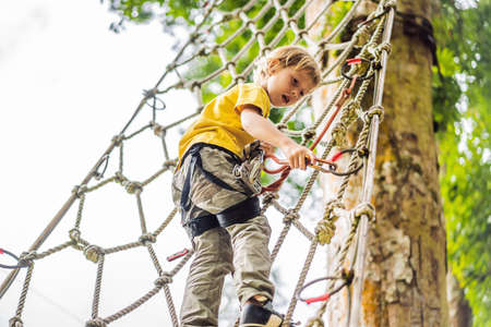 Little boy in a rope park. Active physical recreation of the child in the fresh air in the park....