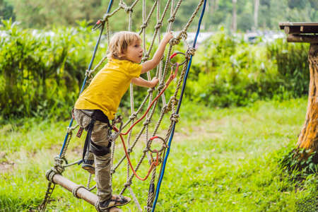 Little boy in a rope park. Active physical recreation of the child in the fresh air in the park. Training for childrenの写真素材