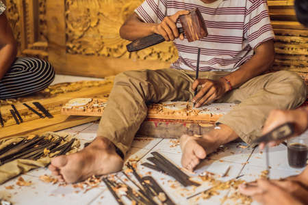 Master wood-carver made using a special knife wooden national dish - a ladle with a patterned...