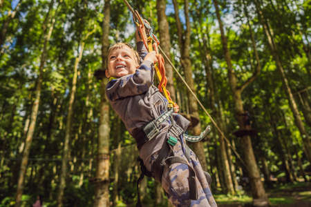 Little boy in a rope park. Active physical recreation of the child in the fresh air in the park....