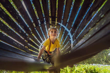 Little boy in a rope park. Active physical recreation of the child in the fresh air in the park. Training for childrenの写真素材