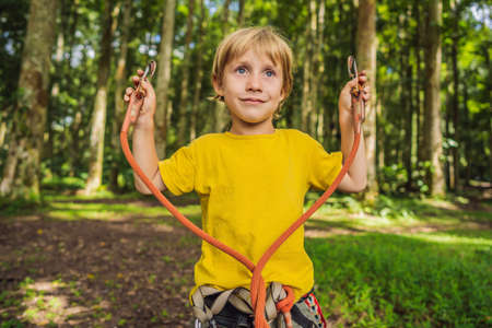 Little boy in a rope park. Active physical recreation of the child in the fresh air in the park. Training for childrenの写真素材