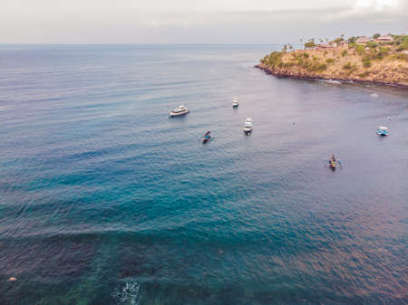 Aerial view of Amed beach in Bali, Indonesia. Traditional fishing boats called jukung on the black...