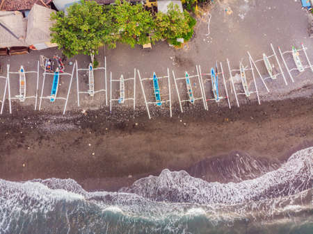 Aerial view of Amed beach in Bali, Indonesia. Traditional fishing boats called jukung on the black...