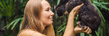 Woman holding a rabbit. Cosmetics test on rabbit animal. Cruelty free and stop animal abuse concept BANNER, LONG FORMATの写真素材