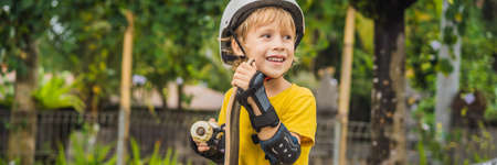 Athletic boy in helmet and knee pads learns to skateboard with in a skate park. Children education,...