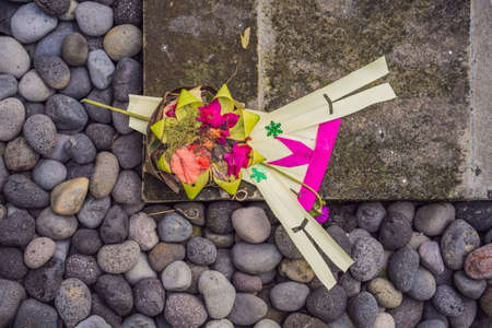 Traditional balinese offerings to gods in Bali with flowers and aromatic sticksの写真素材