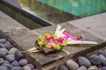 Traditional balinese offerings to gods in Bali with flowers and aromatic sticksの写真素材