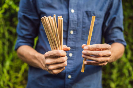 Bamboo drinking straw vs disposable straws in hands. Zero waste concept.の写真素材