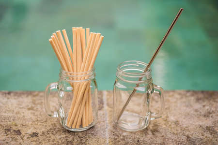 Steel drinking vs disposable straws on pool background. Zero waste conceptの写真素材