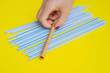 Bamboo drinking straw vs disposable straws on a yellow background. Zero waste conceptの写真素材