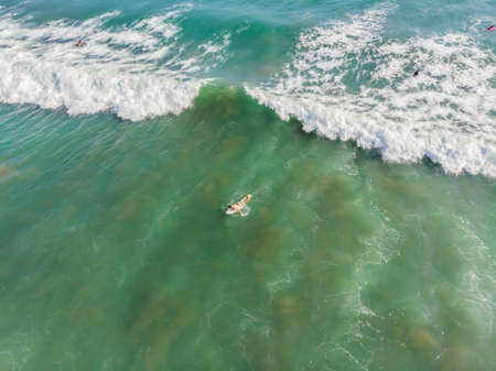 A view from above of the surfers in the ocean