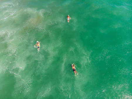 A view from above of the surfers in the oceanの写真素材