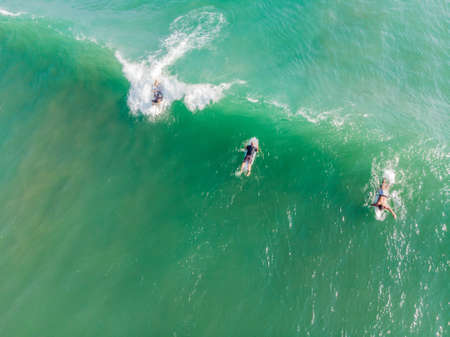 A view from above of the surfers in the ocean