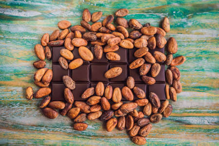 Chocolate and cocoa beans on color wooden backgroundの写真素材