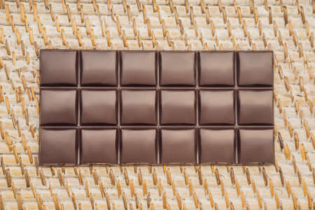 Delicious chocolate bar on a straw whitened backgroundの写真素材