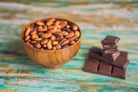 Chocolate and cocoa beans on color wooden backgroundの写真素材