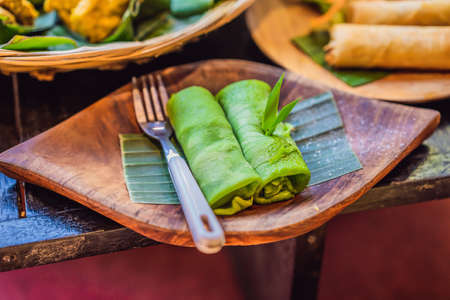 Rolled thin green colored pancake Traditional indonesian foodの写真素材
