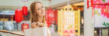 BANNER, LONG FORMAT Woman hold shopping bag against the background of Chinese red lanterns for the Chinese New Year. Big sale in honor of the New Years Eve. Black Chinese Friday 11.11の写真素材