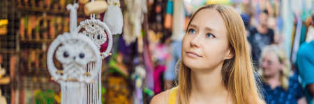 Woman traveler choose souvenirs in the market at Ubud in Bali, Indonesia BANNER, LONG FORMATの写真素材