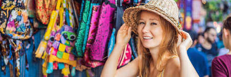 Woman traveler choose souvenirs in the market at Ubud in Bali, Indonesia BANNER, LONG FORMATの写真素材
