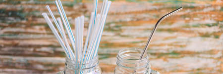 Steel drinking vs disposable straws on painted wooden background. Zero waste concept BANNER, LONG FORMATの写真素材