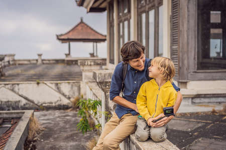 Dad and son tourists in abandoned and mysterious hotel in Bedugul. Indonesia, Bali Island. Bali Travel Conceptの写真素材
