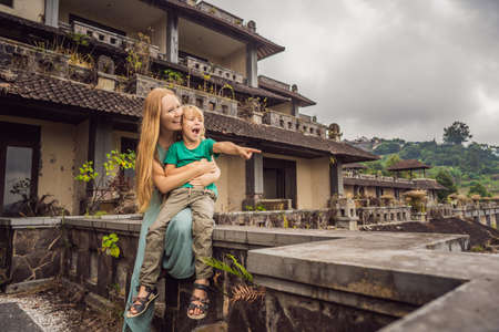 mother and son tourists in abandoned and mysterious hotel in Bedugul. Indonesia, Bali Island. Bali Travel Conceptの写真素材