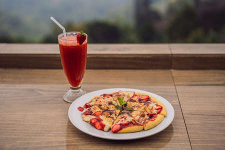 Delicious strawberry pizza on a balinese tropical nature background. Bali island, Indonesiaの写真素材