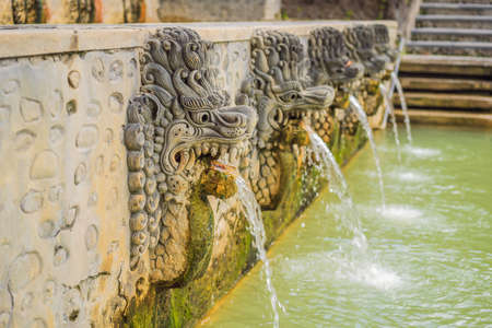 Thermal water is released from the mouth of statues at a hot springs in Banjar, Bali, Indonesiaの写真素材