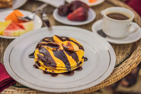 Pancakes with banana and chocolate for breakfast.