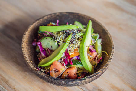 Mixed Green Salad with Grilled Salmon, Quinoa and Avocado on Wood Background Healthy Food Concept.