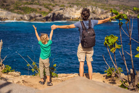Dad and son tourists against the background of the sea Angels Billabong in Nusa Penida, Bali,...