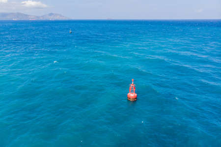 Floating red navigational buoy on blue sea, gulf. Droneの写真素材