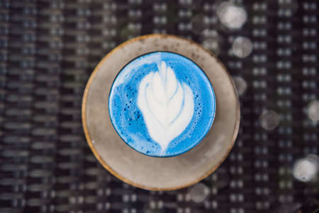 Trendy drink: Blue latte. Top view of hot butterfly pea latte or blue spirulina latte on gray textured background. Copy space for textの写真素材
