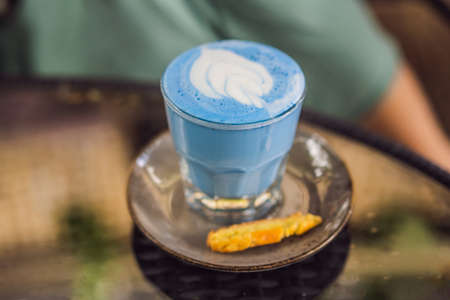 Trendy drink: Blue latte. Top view of hot butterfly pea latte or blue spirulina latte on gray textured background. Copy space for textの写真素材