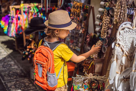 Boy at a market in Ubud, Bali. Typical souvenir shop selling souvenirs and handicrafts of Bali at the famous Ubud Market, Indonesia. Balinese market. Souvenirs of wood and crafts of local residents.の写真素材