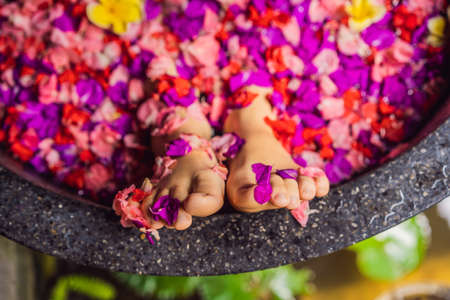 Attractive Young woman in bath with petals of tropical flowers and aroma oils