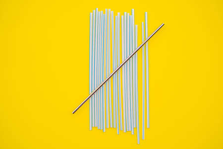 Steel drinking vs disposable straws on a yellow background. Zero waste concept