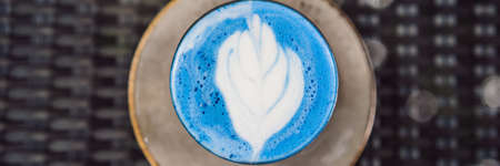 Trendy drink: Blue latte. Top view of hot butterfly pea latte or blue  latte on gray texturedの写真素材