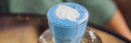 Trendy drink: Blue latte. Top view of hot butterfly pea latte or blue spirulina latte on gray textured background. Copy space for text BANNER, LONG FORMATの写真素材